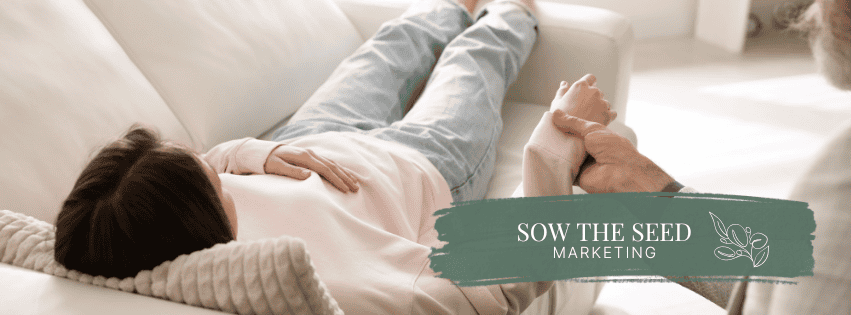 person lying on couch while someone else sits in chair holding hands